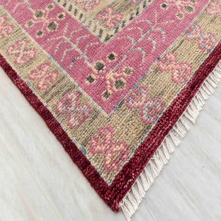Modern hand-knotted rug with bold geometric diamond pattern in burgundy, blush, and ivory colors