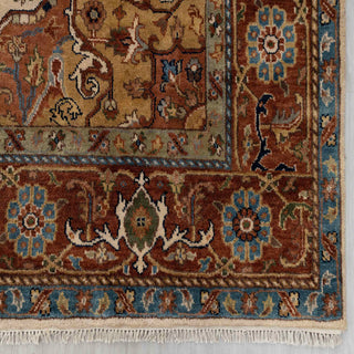 Modern hand-knotted rug with bold geometric medallion pattern in rust, cream, blue accents.