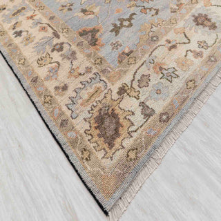 Modern hand-knotted rug with classic blue Oushak floral pattern and ivory border, ideal for living room decor.