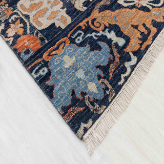 Modern hand-knotted rug with colorful abstract pattern in navy, burnt orange, blue, ideal for living room.