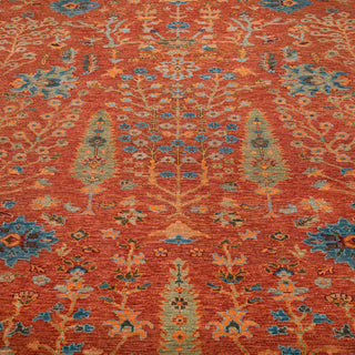 Modern hand-knotted rug with intricate curvilinear floral pattern in terracotta, sage, gold and blue tones.