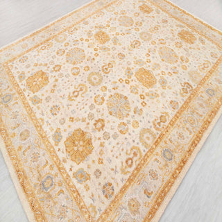 Modern hand-knotted rug with subtle distressed floral pattern in ivory, warm gold tones, 8x10.
