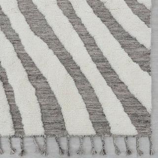 Modern hand-knotted rug with abstract zebra chevron pattern in grey and ivory, tasseled edges