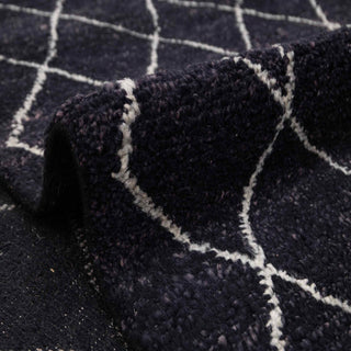 Moroccan Beni Ourain style hand-knotted rug with crisscross diamond motif in black and off-white.