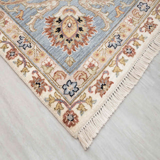 Oriental hand-knotted wool rug in ivory with blue and tan floral border, 8x10 size ideal for bright, elegant interiors.