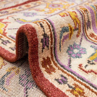 Oushak-style hand-knotted rug with geometric floral medallion motif in rust, teal, lilac, gold tones.