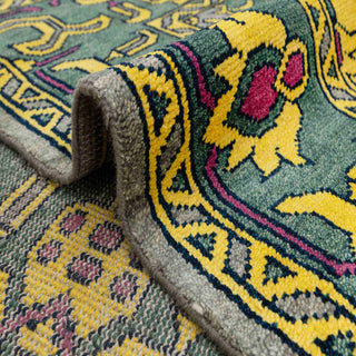 Oushak-style hand-knotted rug with tribal geometric motif in yellow, green, gray and magenta accents.