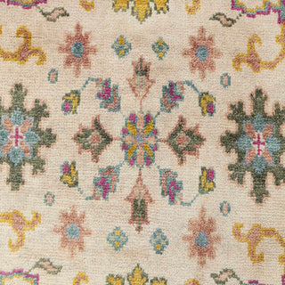 Persian-style hand-knotted rug with colorful floral motif in ivory, yellow, teal, and pink tones.