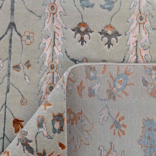 Persian-style hand-knotted rug with delicate garden motif in soft sage, blush, and blue tones.