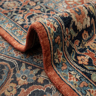 Persian-style hand-knotted rug with intricate allover floral motifs in warm rust, navy, teal, and beige, classic 8x10 size