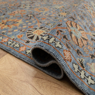 Persian Herati style hand-knotted rug with dense floral motifs in denim blue, terracotta and cream tones.