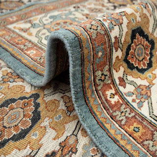 Persian Heriz Serapi hand-knotted rug with bold floral motif in blue field, ivory and rust borders.