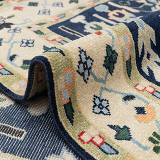 Persian garden style hand-knotted rug with stylized trees, flowers and vases on deep blue field and ivory border.

