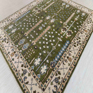 Persian style hand-knotted rug with garden and vine motifs in olive, cream, blue and gold tones.