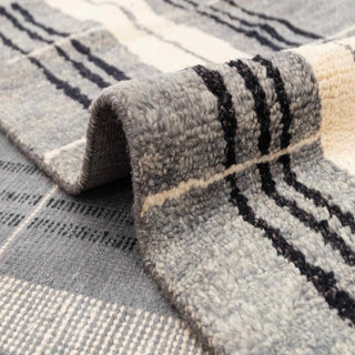 Scandinavian-style hand-knotted rug with linear stripe motif in grey, black, and beige.