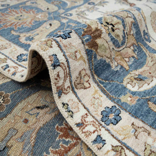 Traditional Agra/Persian hand-knotted rug with curvilinear floral motifs and wide blue border in ivory and gold tones