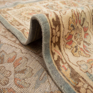 Traditional Oushak-style hand-knotted rug with scrolling floral motifs in blue, cream, gold, 8x11.