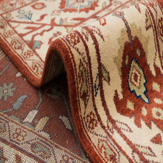 Traditional Persian-style hand-knotted rug with floral and leaf motifs in rust, cream, blue, green.