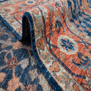 Traditional Persian style hand-knotted rug with cypress, vase and floral garden motifs on deep navy field.