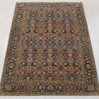 Traditional hand-knotted rug in blue, gold, and rust with dense Persian floral design, 6x9 size.