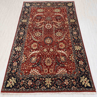 Traditional hand-knotted rug in deep red, navy, and ivory with intricate Persian floral design, 6x9 size
