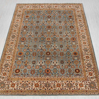 Traditional hand-knotted rug in light blue, ivory, and gold with dense allover floral design, 8x10 size.