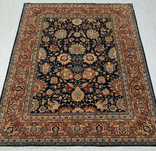 Traditional hand-knotted rug in navy, gold, and rust with dense Persian floral design, classic 8x10 rug