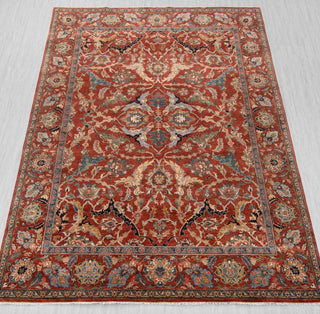 Traditional hand-knotted rug in rust, blue, and beige with dense Persian floral design, 8x10 size
