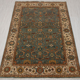 Traditional hand-knotted rug in teal blue, ivory, and rust with Persian floral lattice design, 6x9 size.
