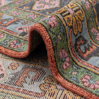 Tribal Persian-style hand-knotted rug with central medallion motif in terracotta, teal, and pink.