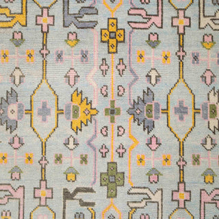 Turkish-style Oushak hand-knotted rug with tribal floral motifs in soft pink, light blue, and grey accents