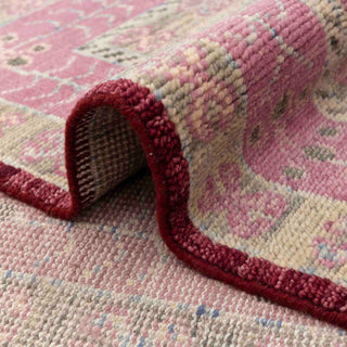 Turkish-style hand-knotted rug with large central diamond motif in red, pink, and beige tones