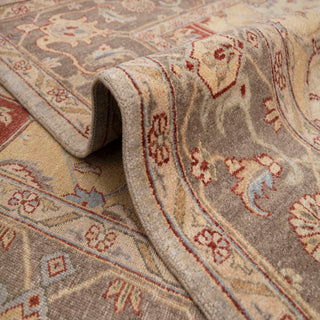 Turkish Oushak-style hand-knotted rug with decorative floral motifs in beige, brown, gold, rust tones.