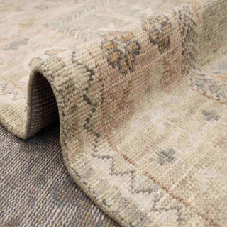 Turkish Oushak-style hand-knotted rug with faded floral lattice motif in sage, ivory, tan tones.