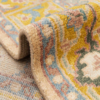 Turkish Oushak-style hand-knotted rug with scattered floral medallion motif in camel, gold, teal.