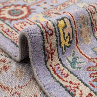 Turkish Oushak-style hand-knotted rug with scattered tribal floral motif in purple, yellow, green.