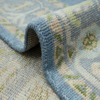 Turkish Oushak hand-knotted rug with muted botanical motif in washed blue and light multicolor tones