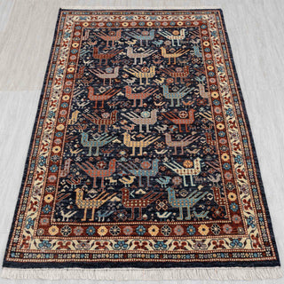 Wool hand-knotted rug in navy, rust, and gold with tribal bird design, 4x6 size.