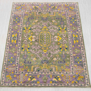 Wool hand-knotted rug in olive green, lavender, and yellow with playful floral design, 8x10.