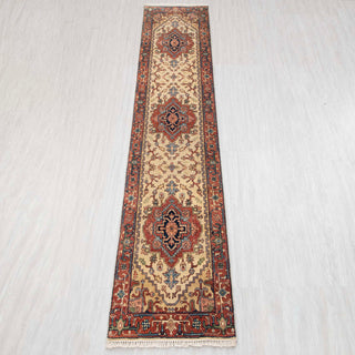 Wool hand-knotted runner rug in ivory, rust, and navy with geometric medallion design, 2.6x10.